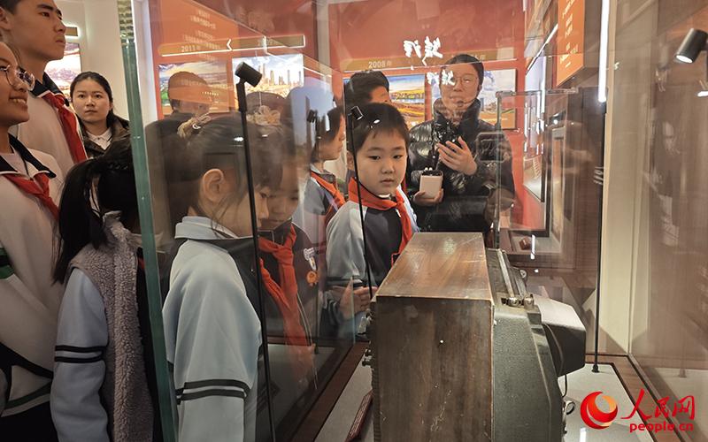 学生们透过天津生产的全国第一台电视机了解天津发展。人民网记者 孙一凡摄