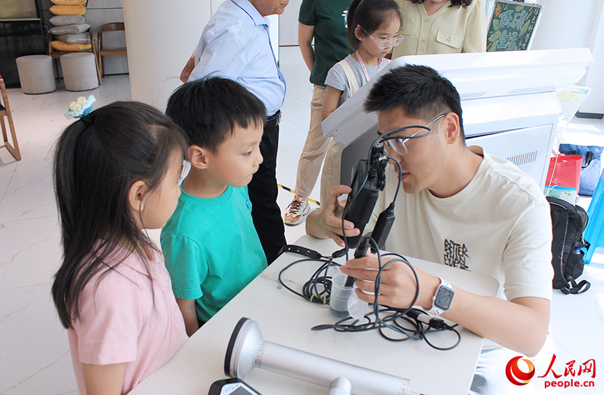 工作人员给孩子们展示环境监测设备。人民网记者 张静淇摄